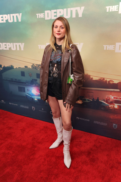 Frances Bean Cobain wearing a leather jacket tshirt shorts and boots